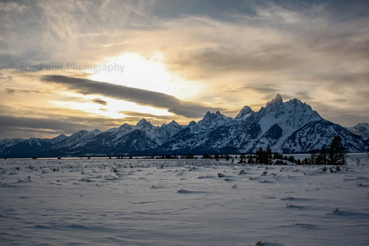 Mist%20caught%20the%20Grand%20Teton%20as%20the%20sun%20sets%20behind%20the%20mountains%20in%20Grand%20Teton%20National%20Park.