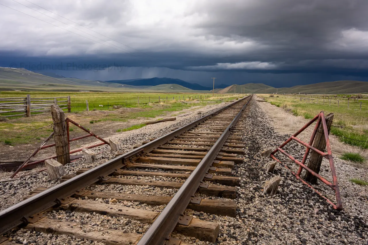 Railroad%20tracks%20lead%20to%20a%20dark%20storm%20in%20Montana.