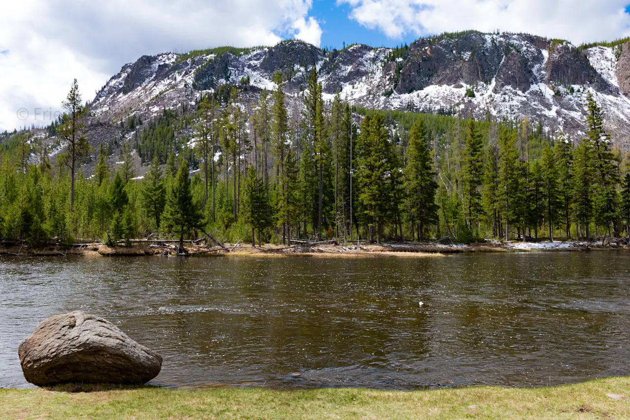 A%20boulder%20sits%20silently%2C%20watching%20the%20river%20flow%20by%20in%20Yellowstone%20National%20Park.